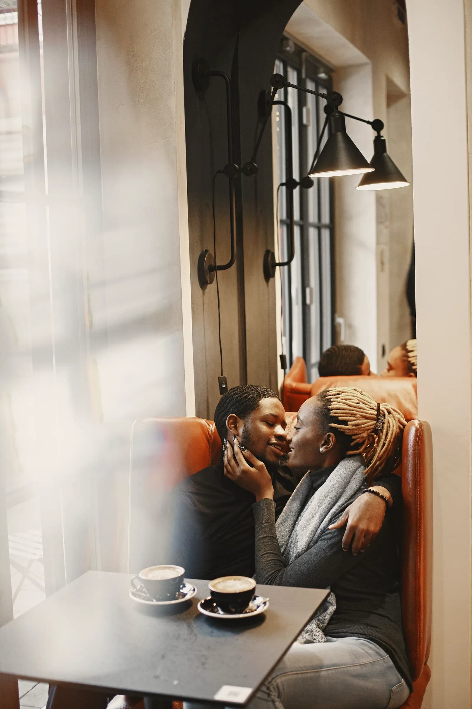 Sarah and Michael sitting close together in a cafe booth.